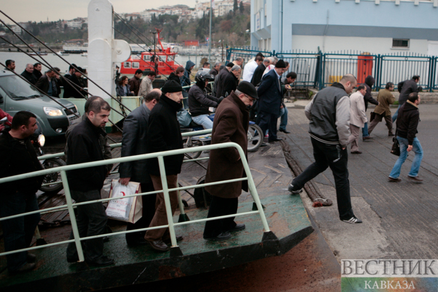 Люди выходят с автомобильного парома